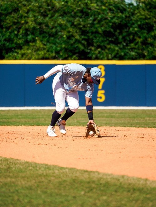 Allan Gil-Fernandez reaching for a ground ball in photo from ShotByRAC sports photography